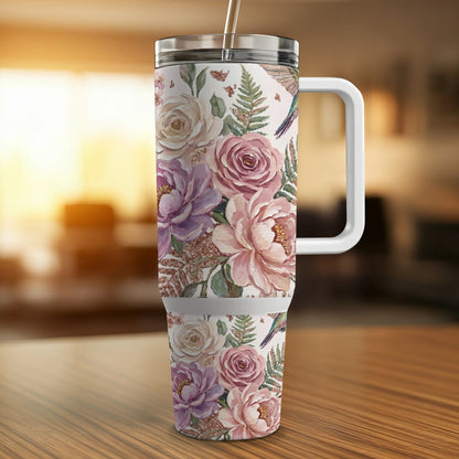 Floral tumbler with handle, featuring roses and ferns, on a wooden table.