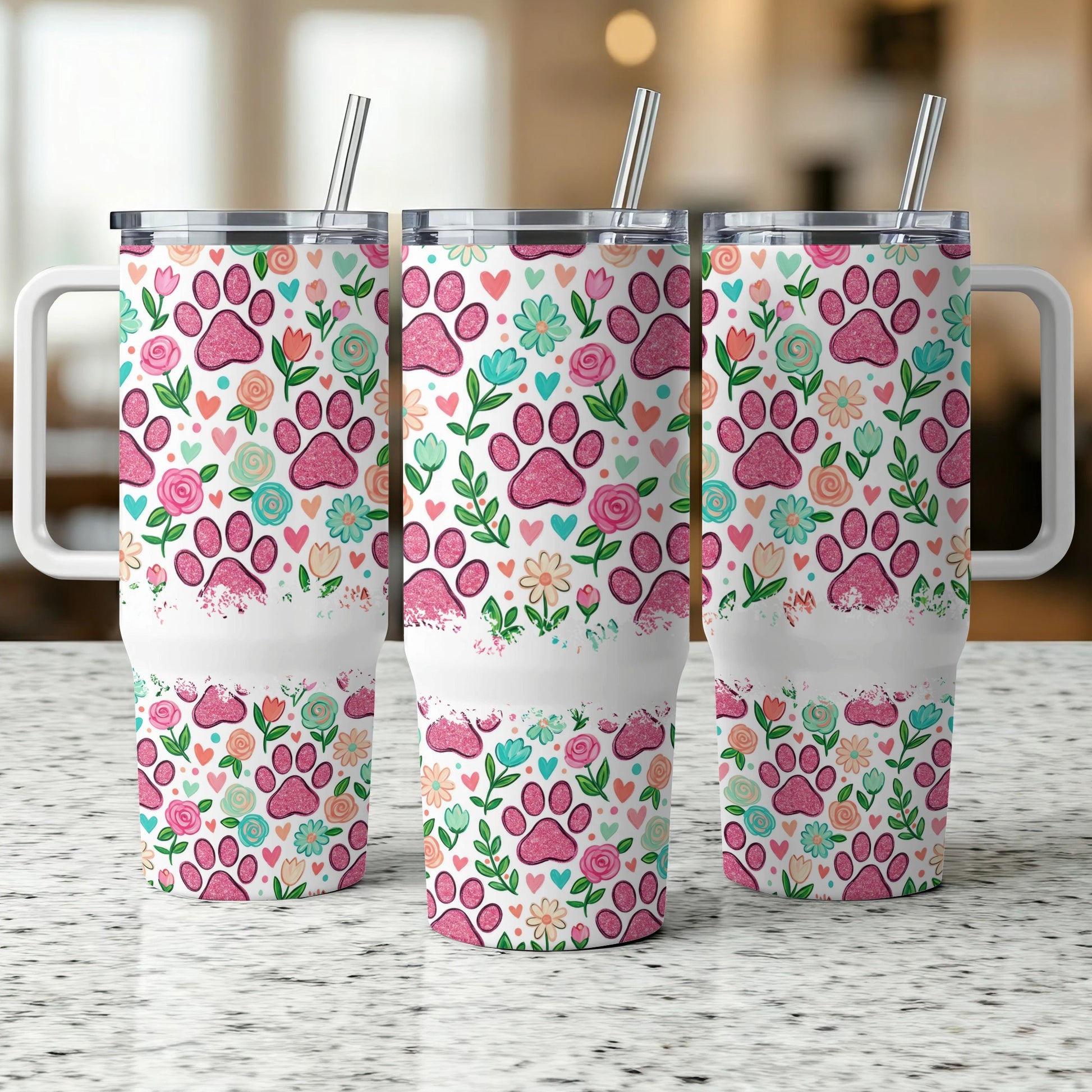 Three tumblers with pink paw print and floral pattern, featuring handles and straws.