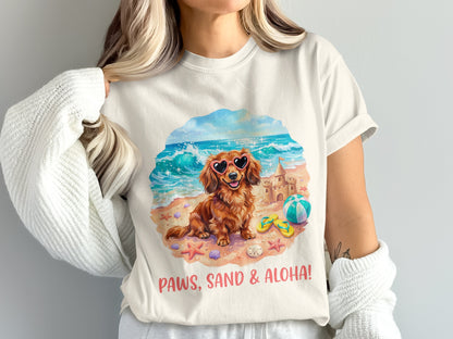 Dachshund wearing heart sunglasses on a beach with text "Paws, Sand & Aloha!".