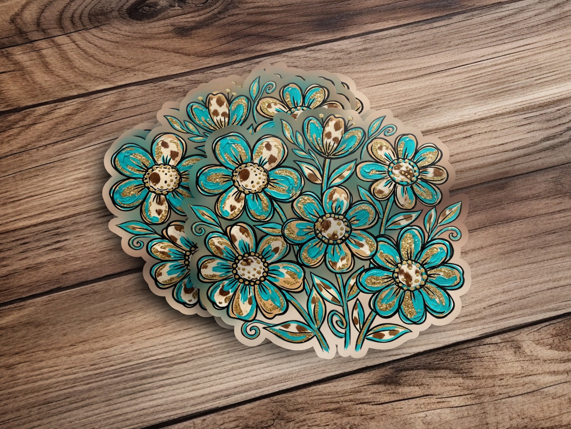 Bouquet of teal and gold floral stickers on wooden background.