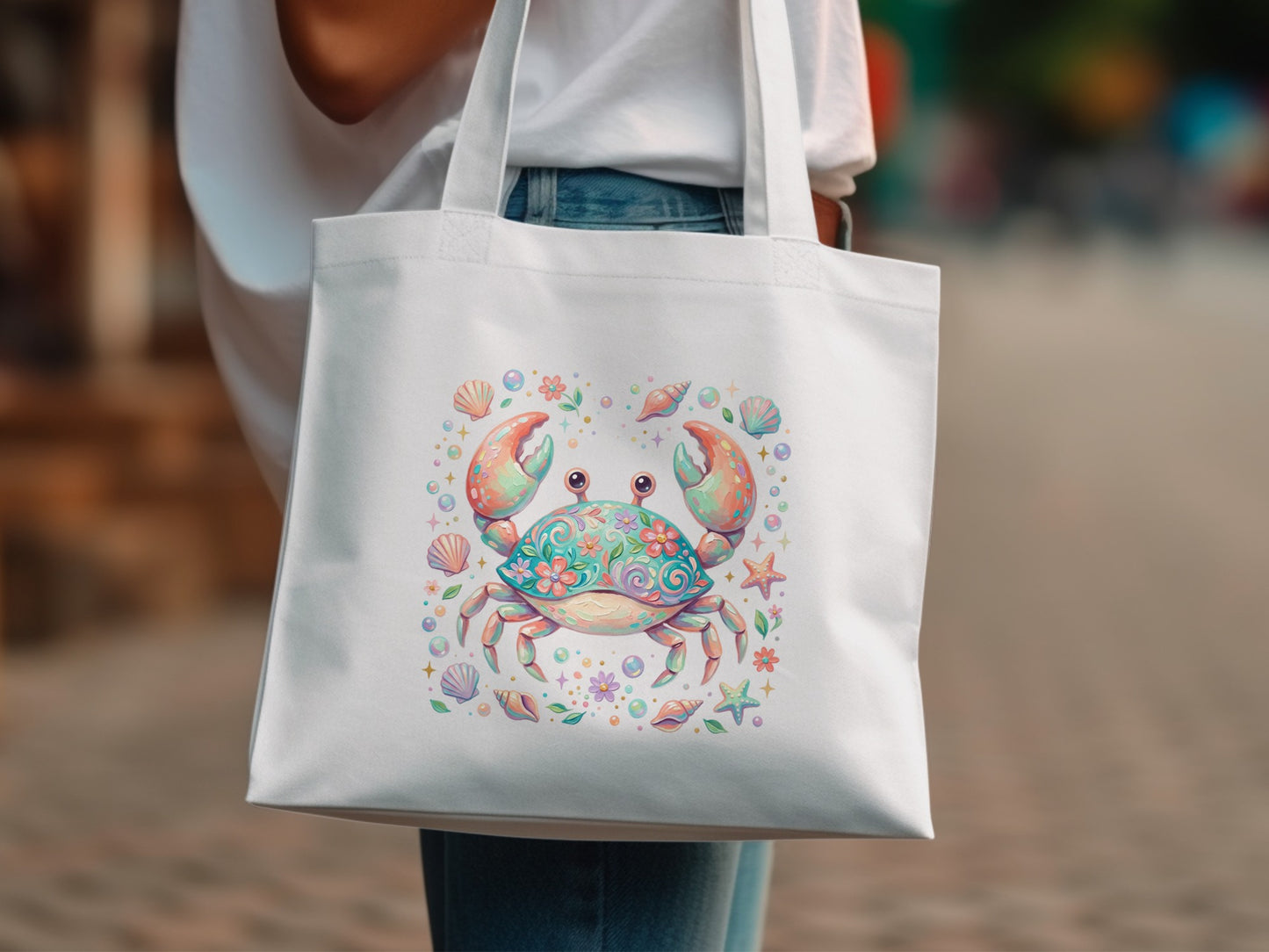White tote bag featuring a colorful, cartoon-style crab with shells and starfish.