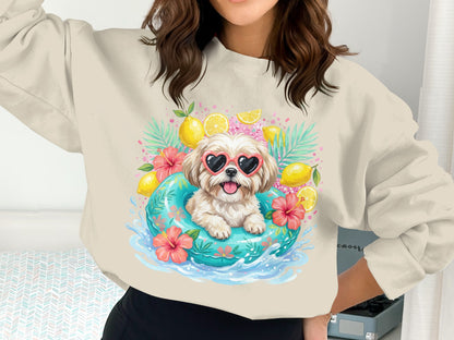 Dog in inner tube with sunglasses, lemons, and tropical leaves on a sweatshirt.