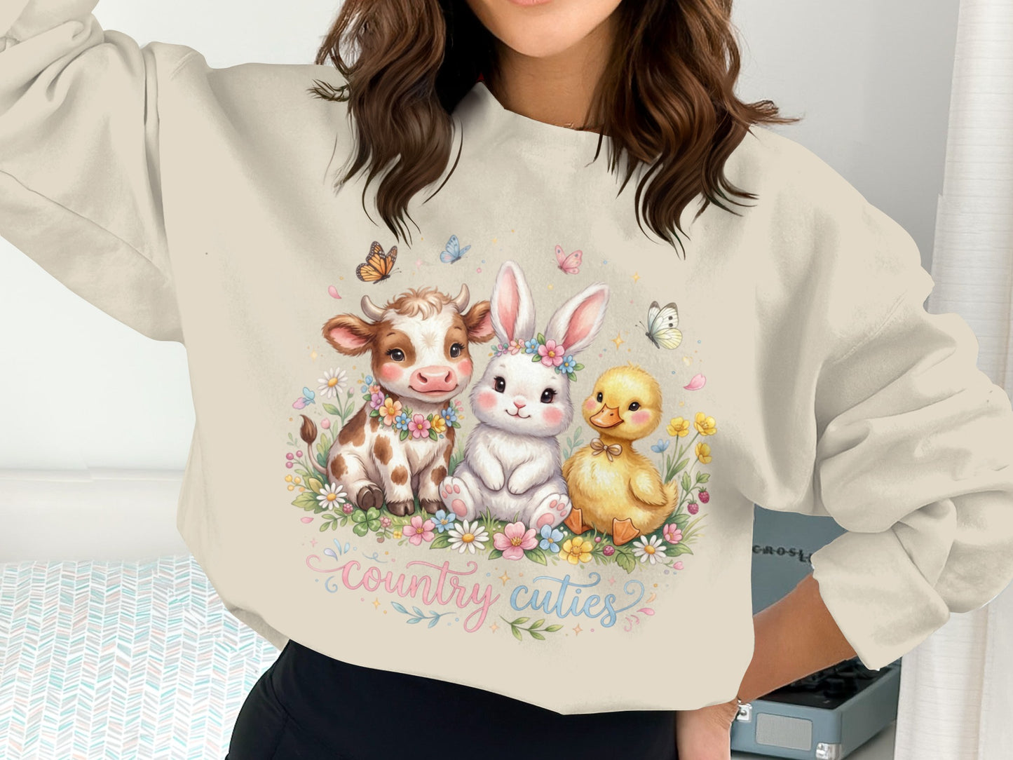 Cow, bunny, and duckling in a floral meadow, with "country cuties" text.