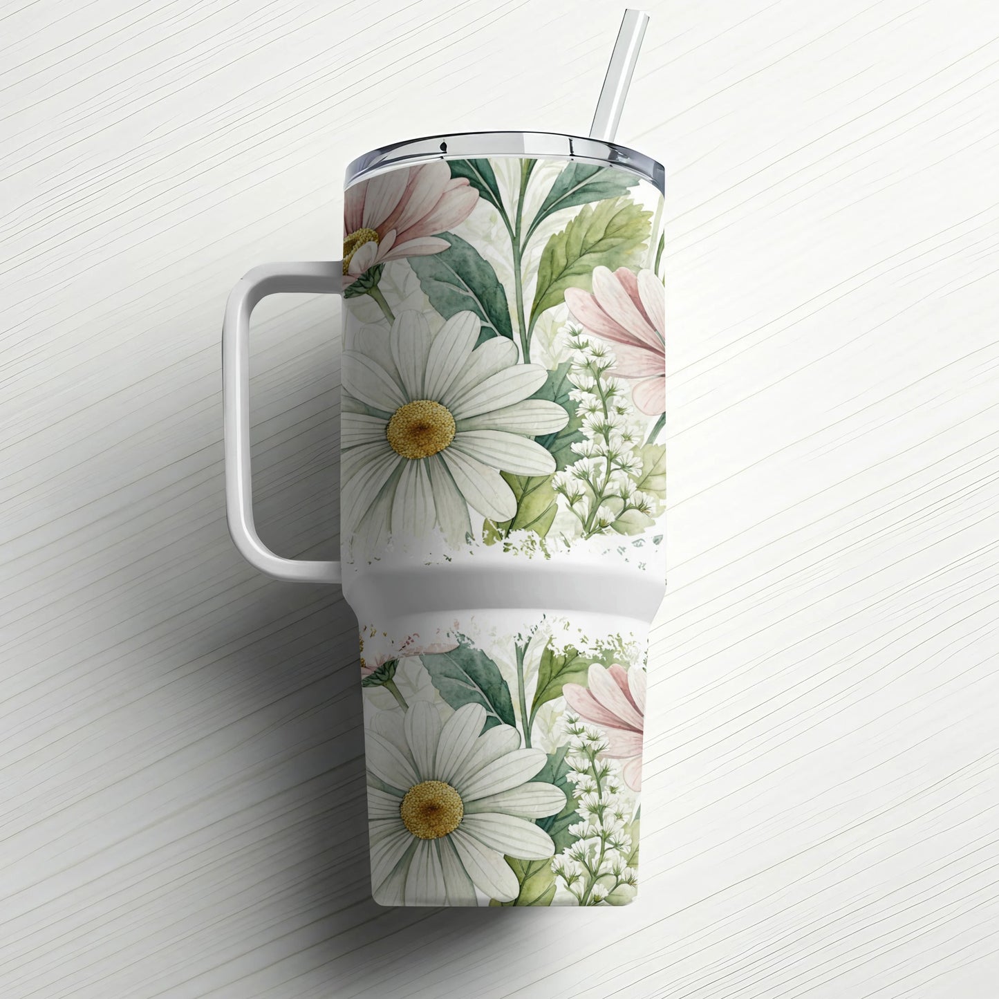 White tumbler with floral pattern and handle, straw inserted.