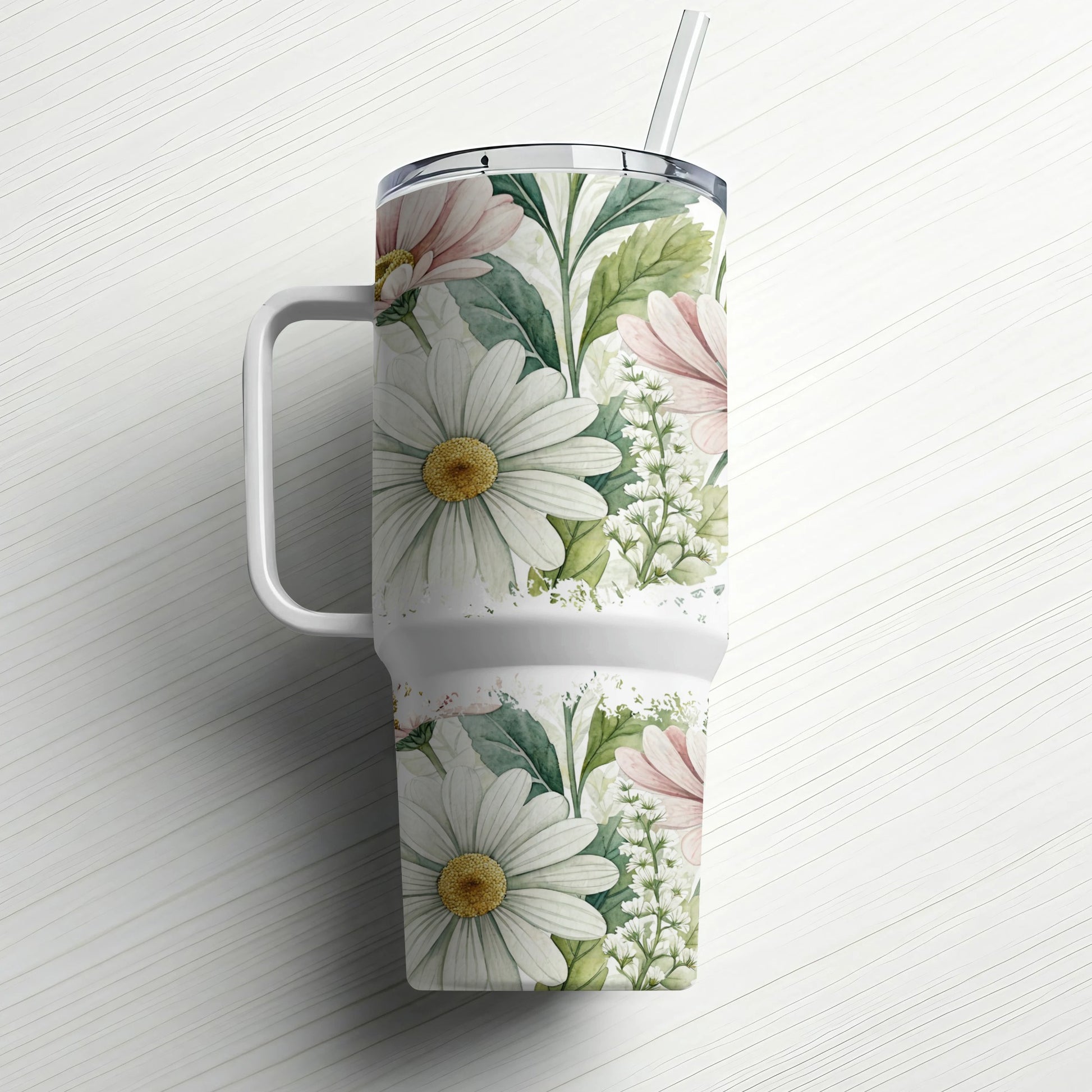 White tumbler with floral pattern and handle, straw inserted.