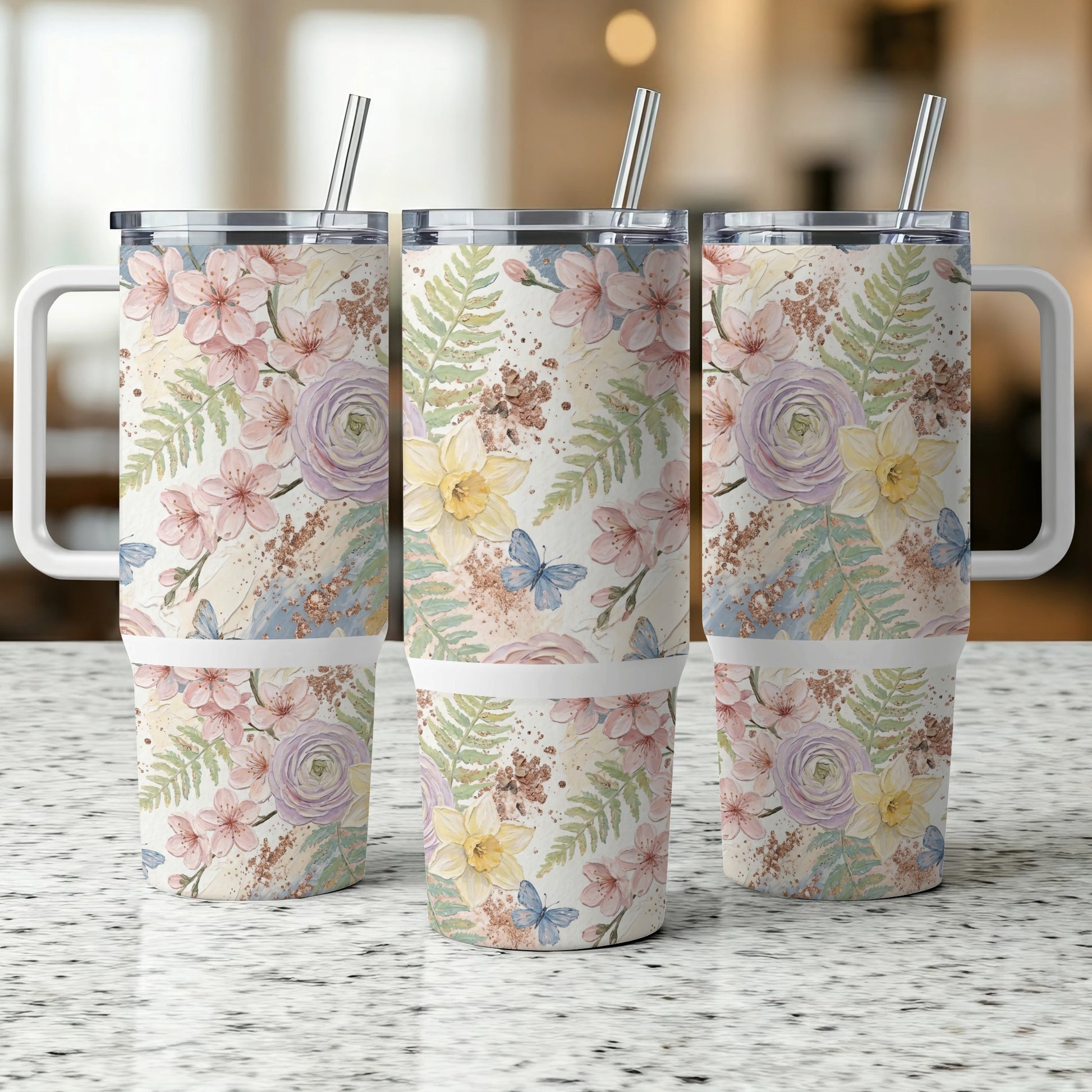 Three tumblers with floral and butterfly pattern, featuring handles and straws.