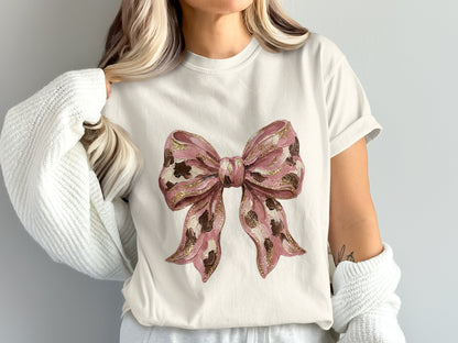 White t-shirt with pink leopard print bow graphic.
