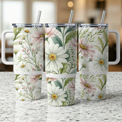 Three tumblers with daisy and floral patterns sit on a counter.