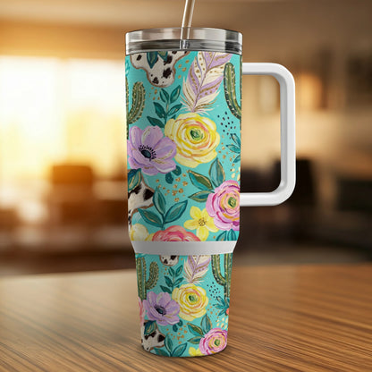 Turquoise tumbler with cowboy boot and floral pattern, white handle and straw.