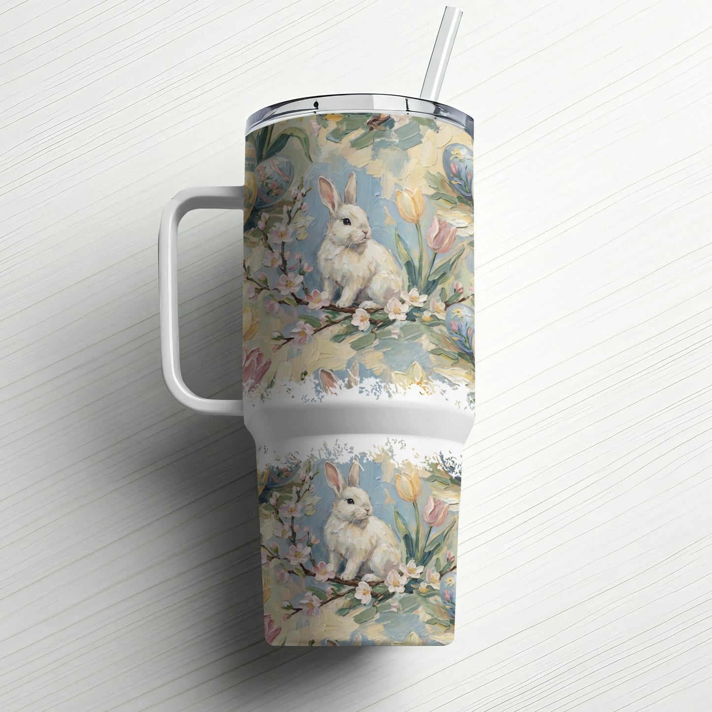 White tumbler with a floral and bunny design, and a straw.