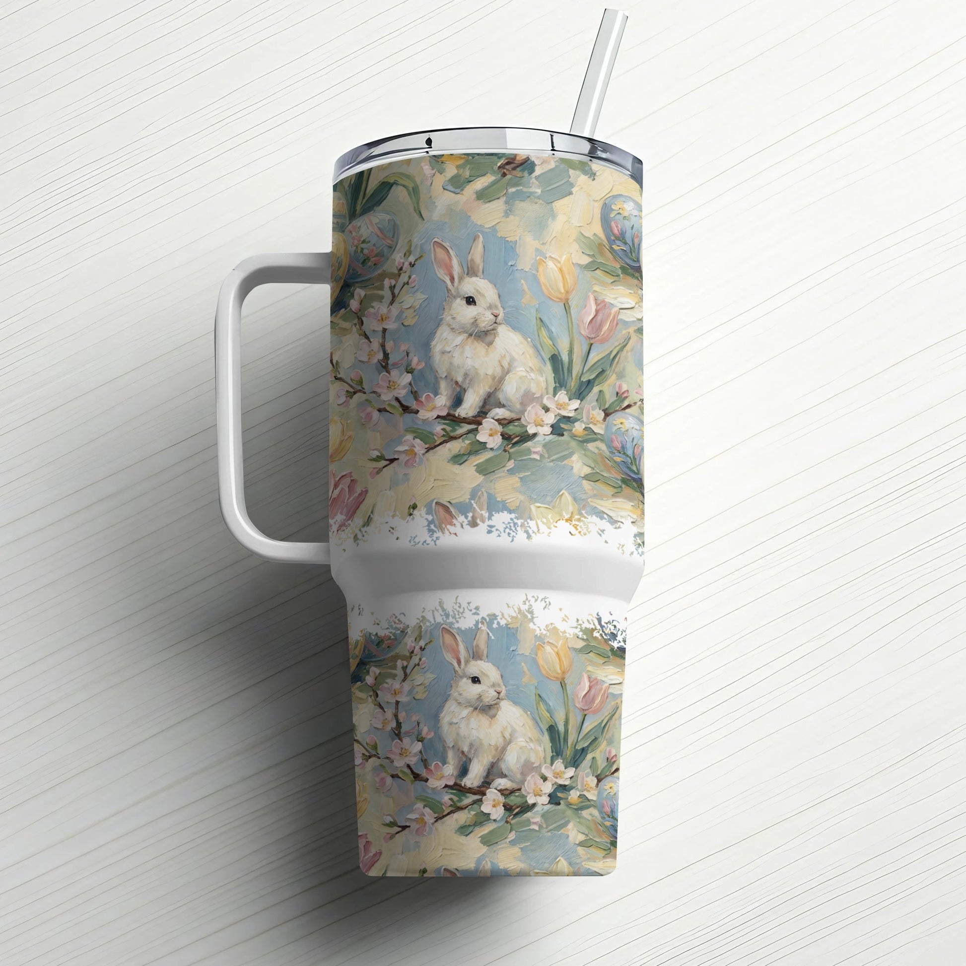 White tumbler with a floral and bunny design, and a straw.