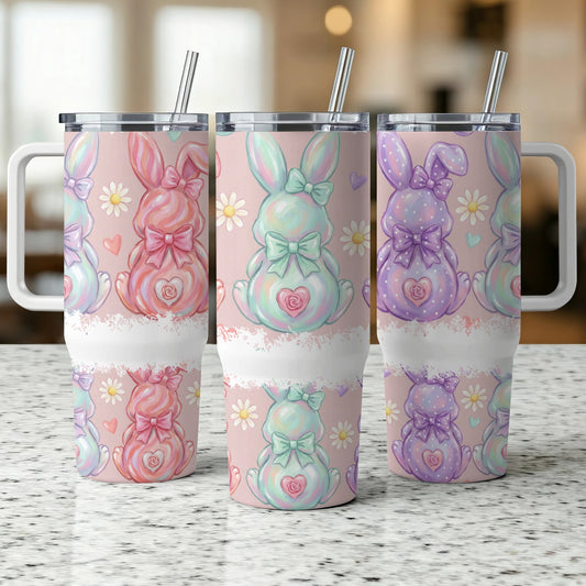 Three pastel bunny tumblers with bows and daisy accents.