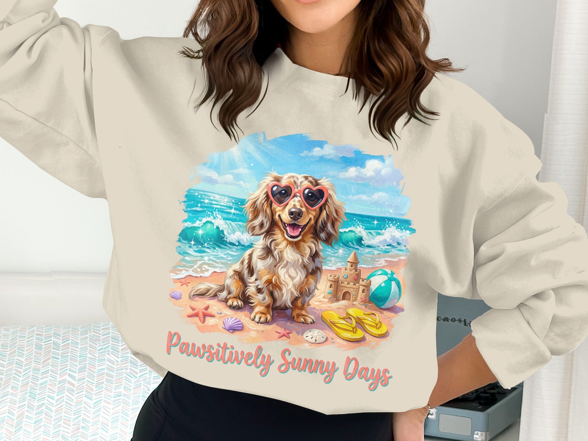 Dachshund in heart sunglasses on beach with sandcastle and text "Pawsitively Sunny Days".