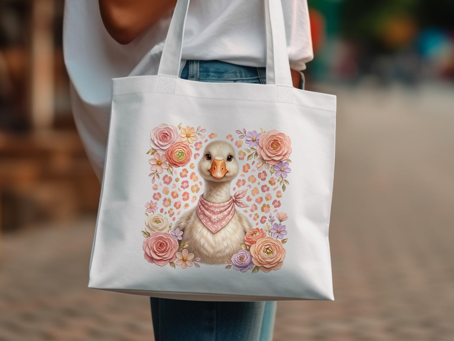 White tote bag with a cute duckling illustration surrounded by flowers.