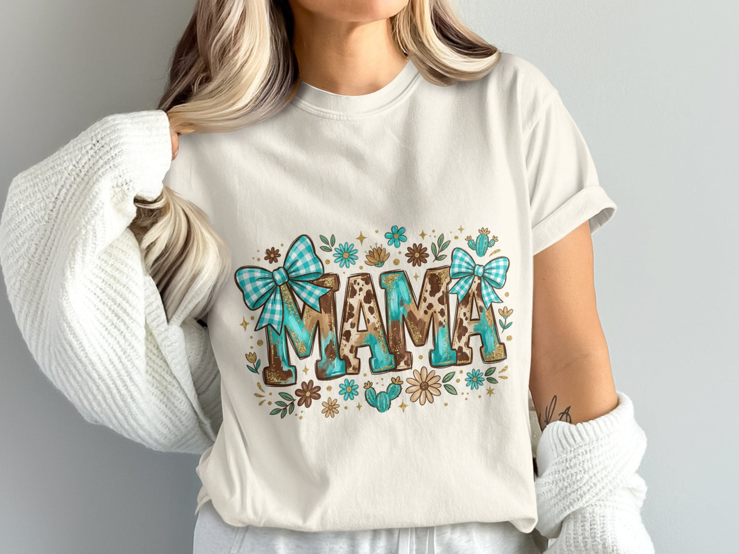 Cream t-shirt with "MAMA" in leopard print, turquoise bows, flowers, and cacti.