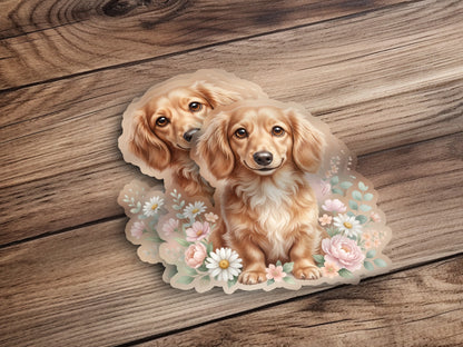 Two dachshund puppies with flowers on a wooden background.