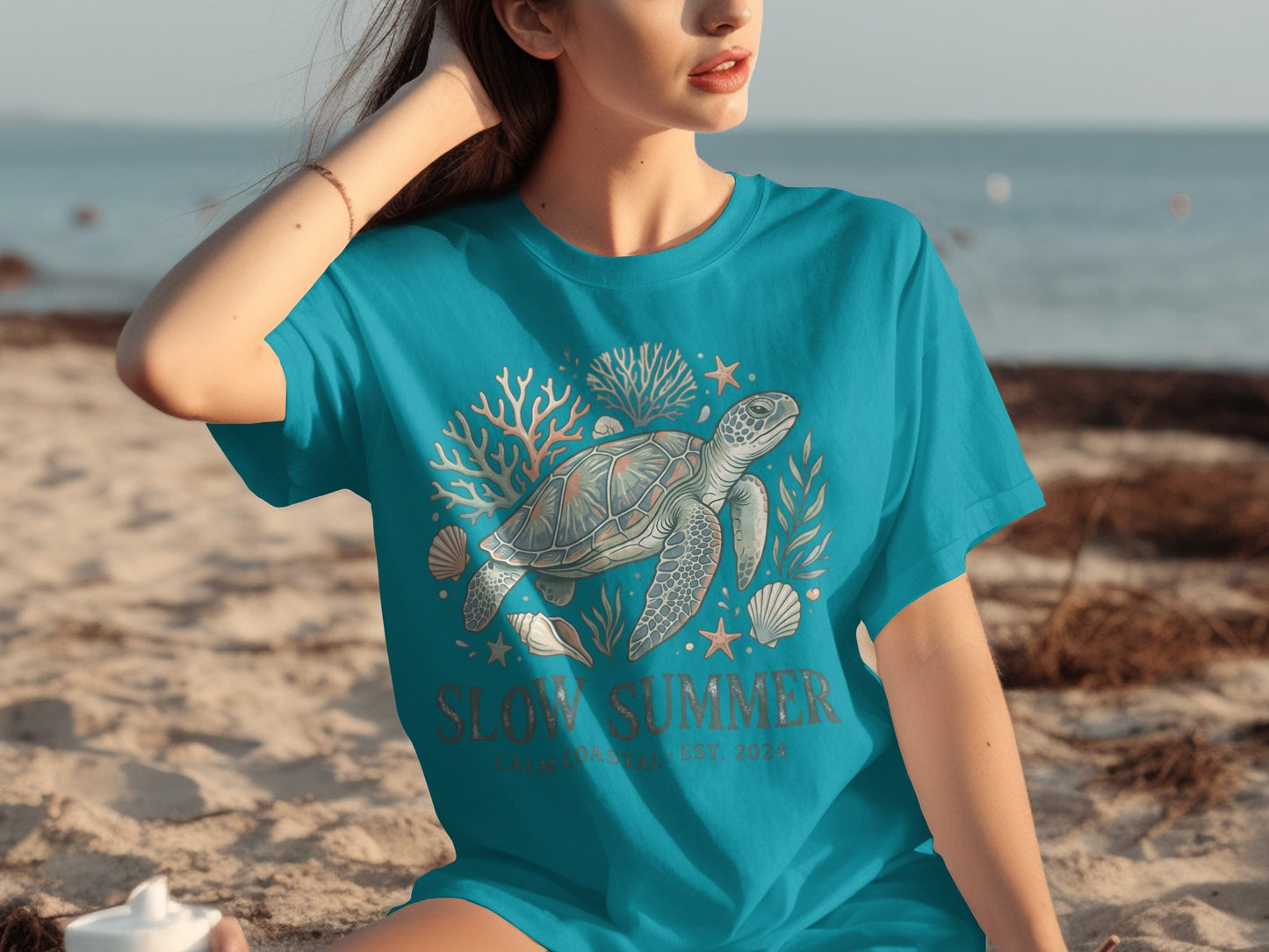 Turquoise t-shirt with a sea turtle, coral, and starfish graphic.