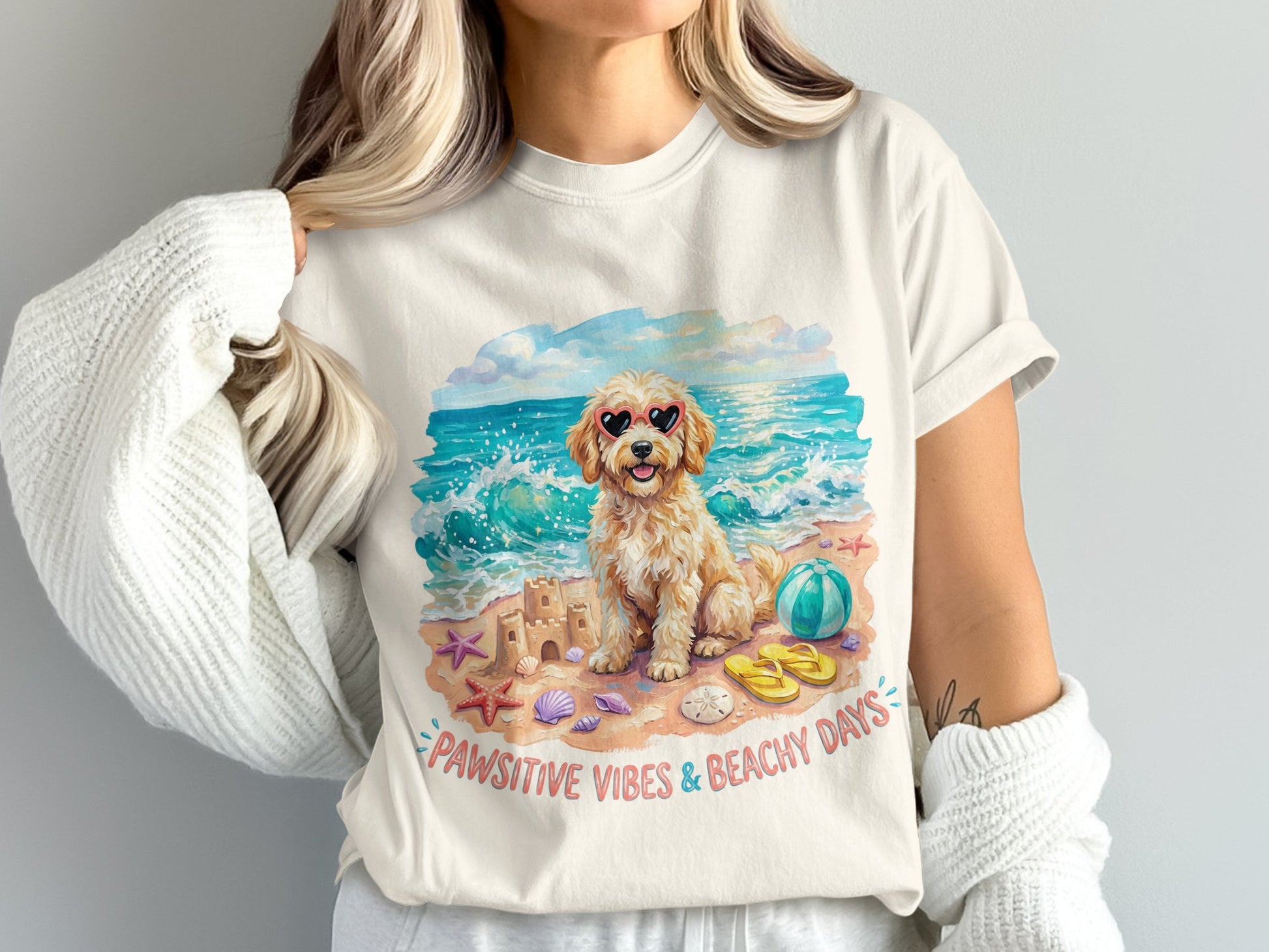 Dog in heart sunglasses on beach with sandcastle and beach ball.