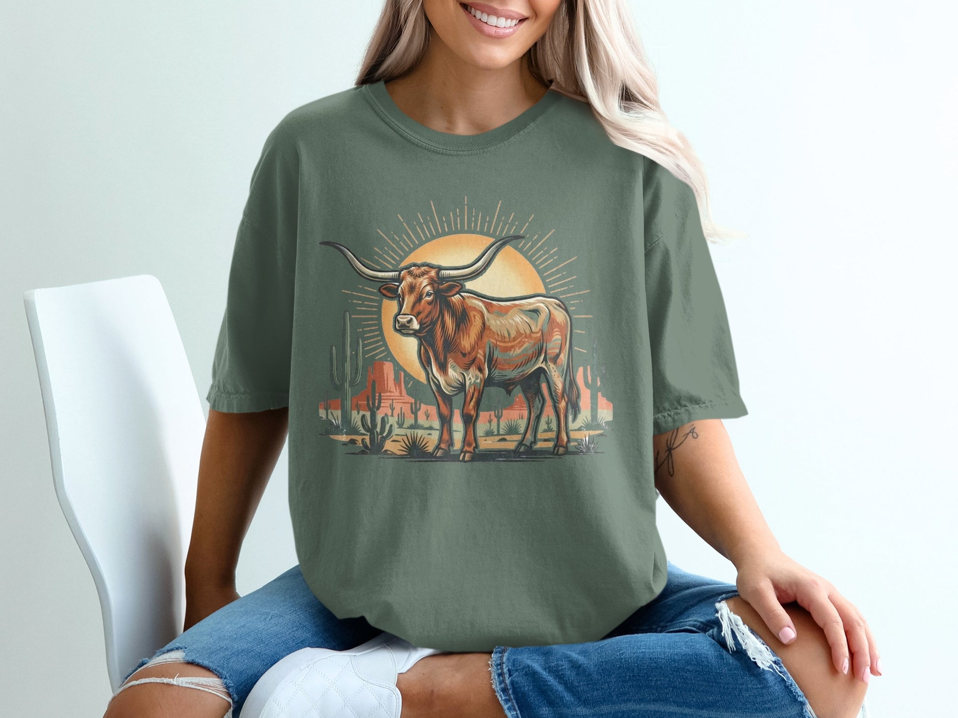 T-shirt with a longhorn steer in a desert landscape with cacti and a sunburst.