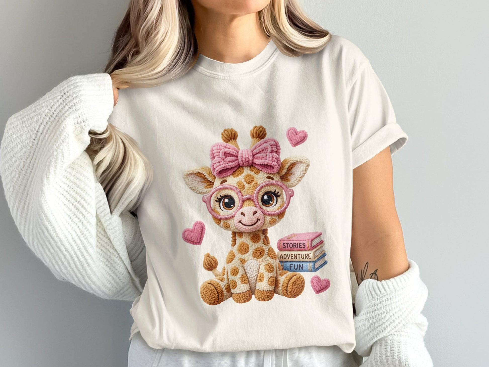 Giraffe with pink bow and glasses sits near books, smiling.