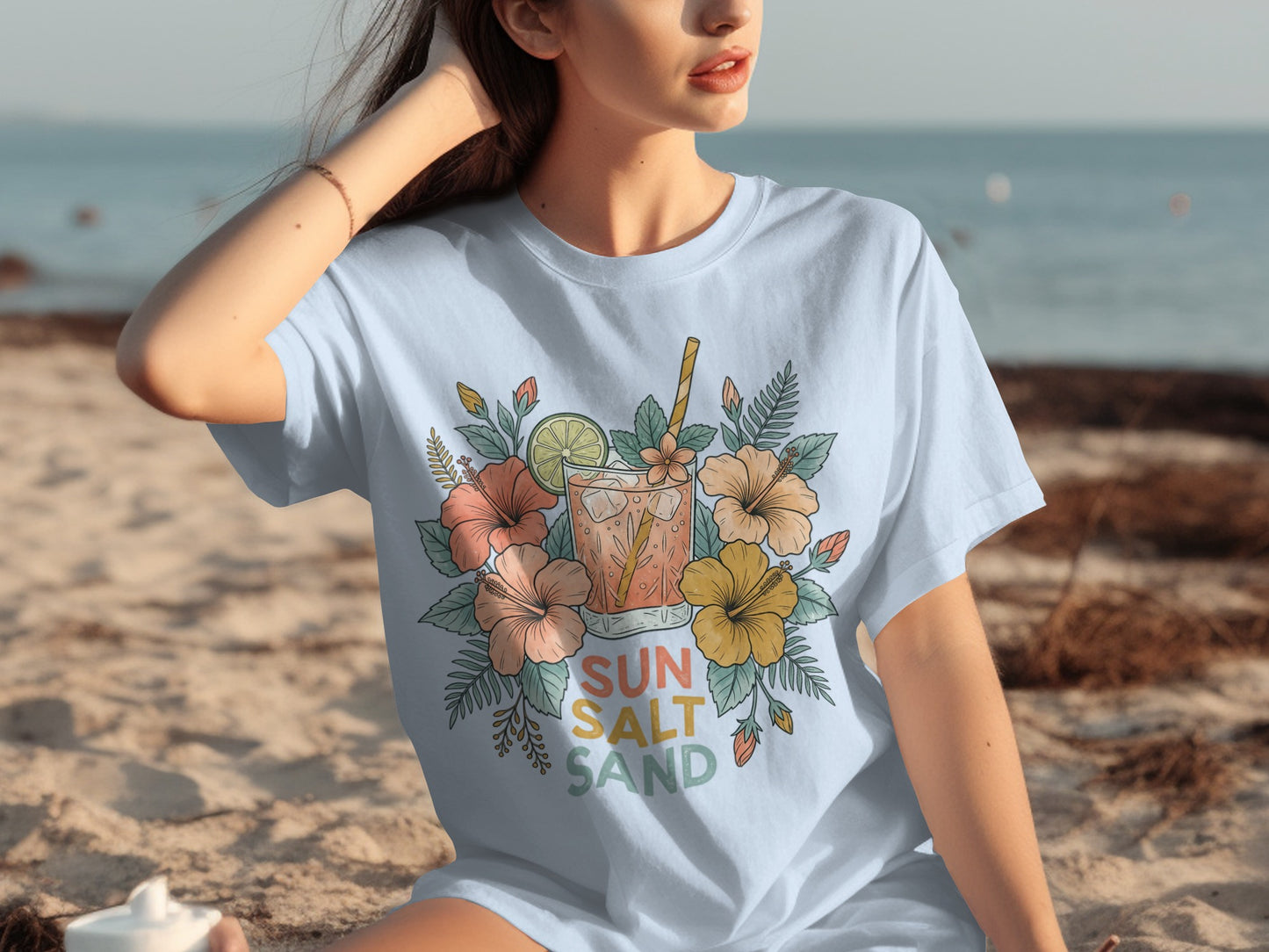 T-shirt with floral design and a tropical drink, reads "Sun Salt Sand".