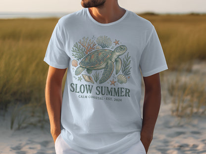 White t-shirt with a sea turtle, coral, and shells graphic and "SLOW SUMMER" text.