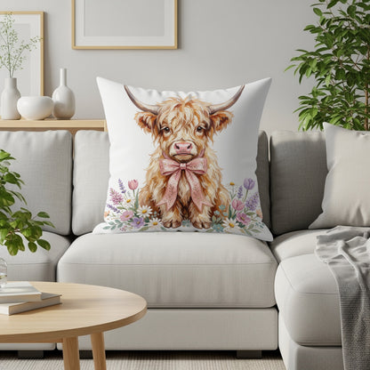 Highland cow with pink bow on a decorative pillow with flowers.