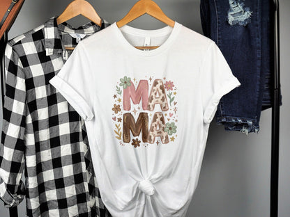 White t-shirt with floral "MAMA" text and decorative flowers.
