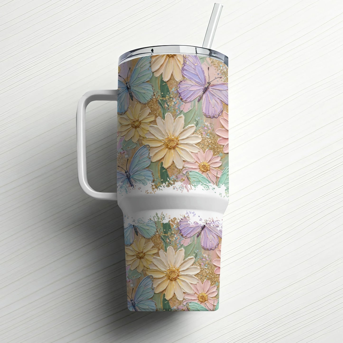 Floral and butterfly tumbler with handle and straw on white background.