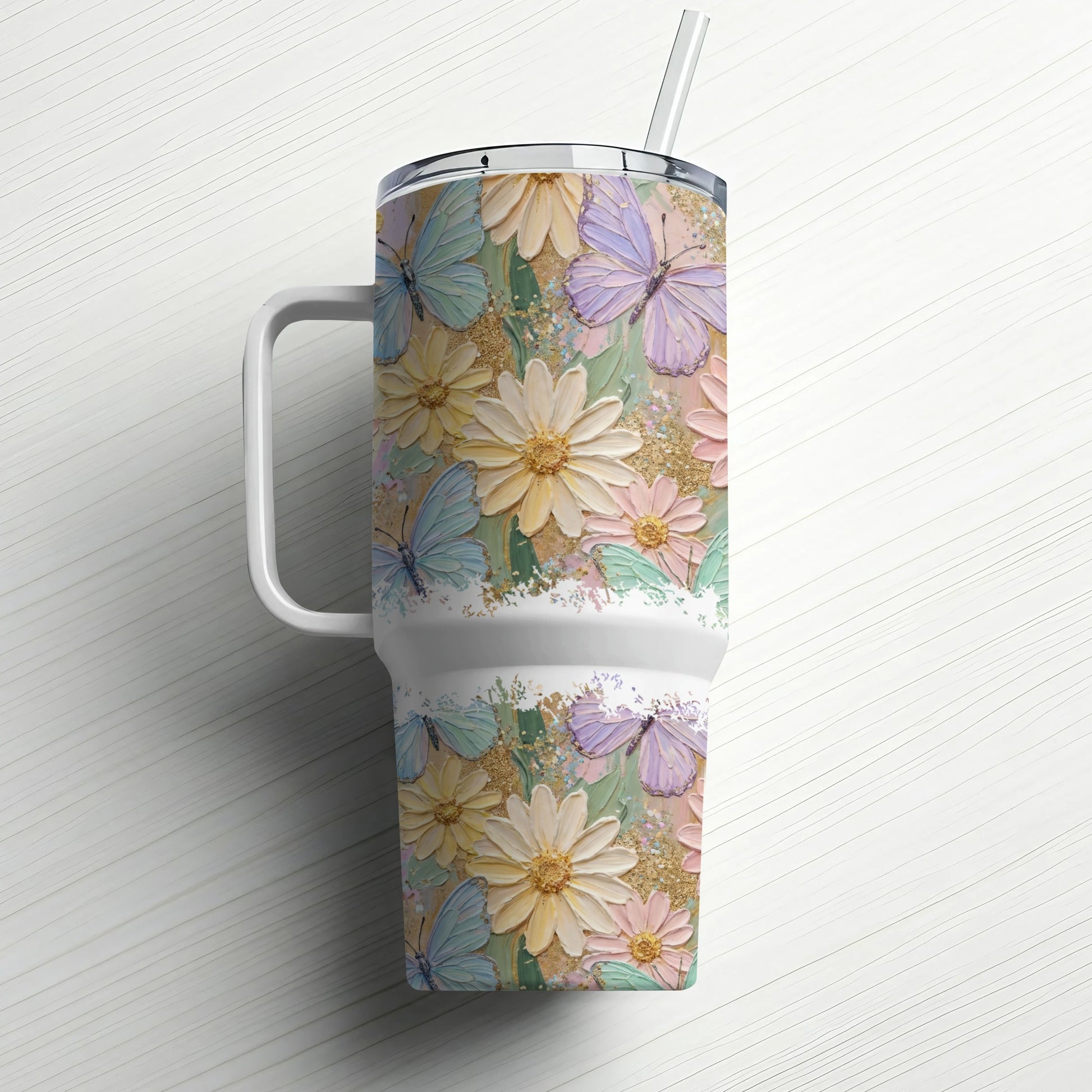 Floral and butterfly tumbler with handle and straw on white background.