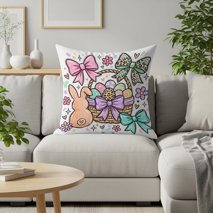 Easter basket with eggs, bunny, and bows on a white couch pillow.