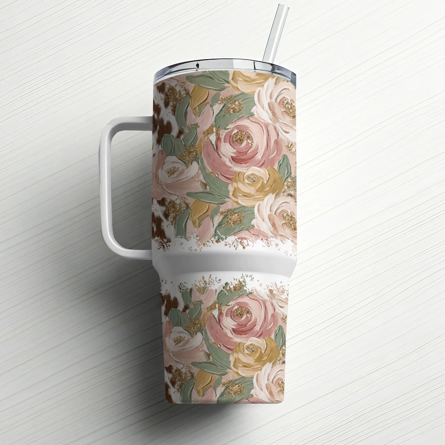 Floral patterned tumbler with straw on a white wood background.