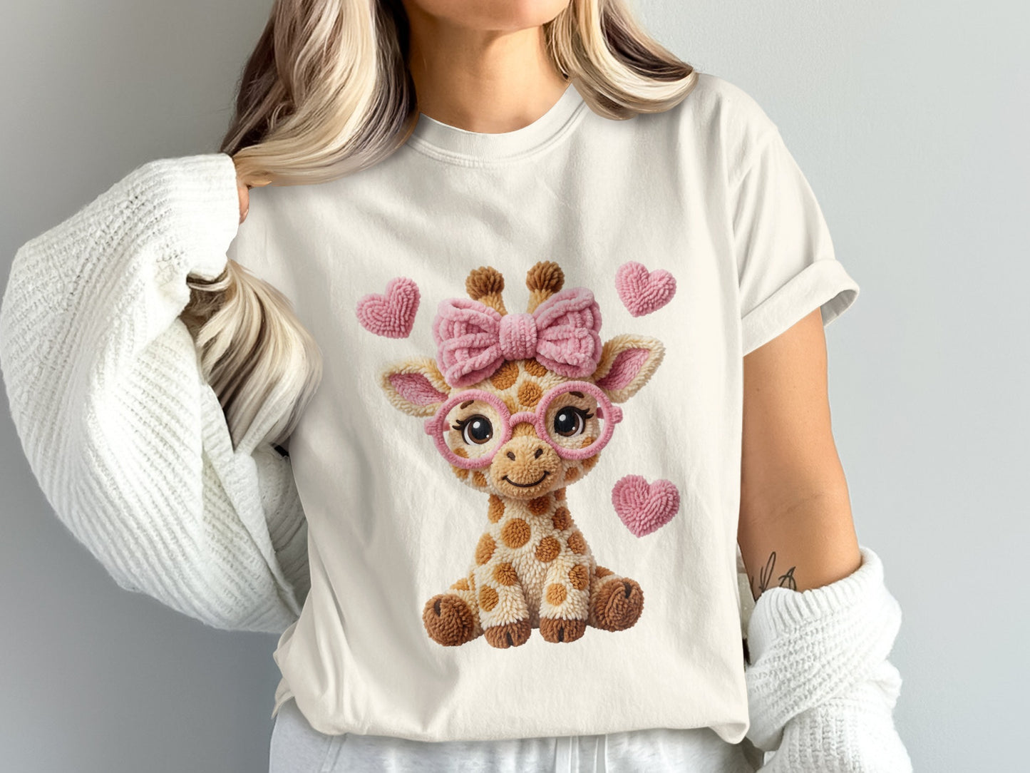 Plush giraffe wearing a pink bow and glasses with hearts.