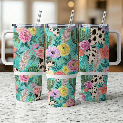 Three floral, cactus, and cow print tumblers with handles and straws.