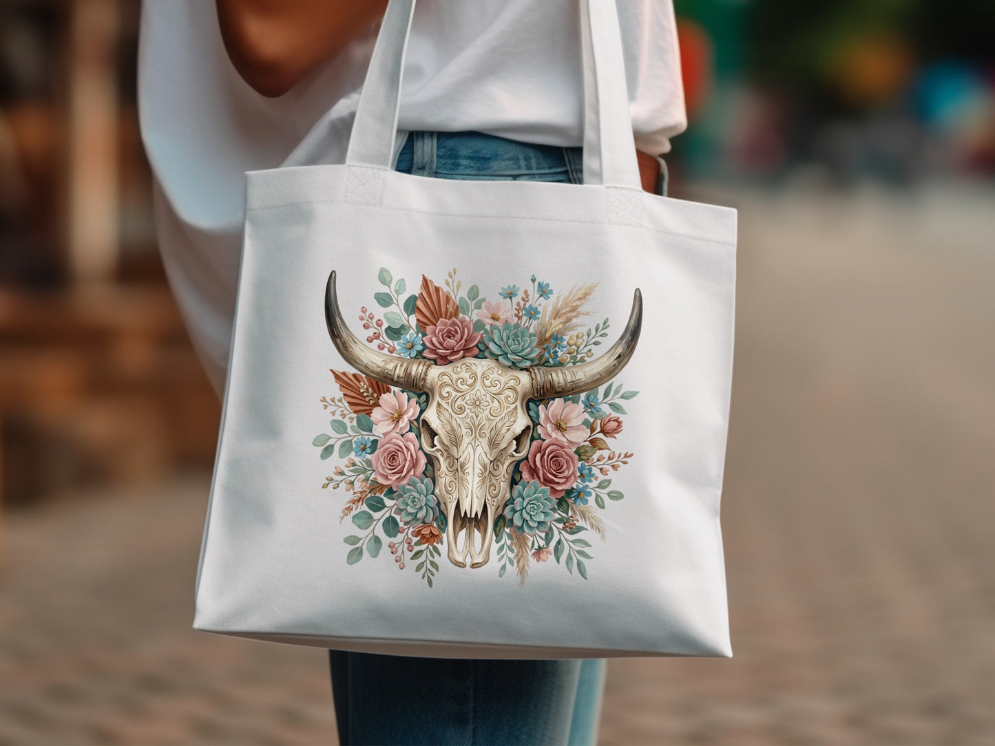 White tote bag with bull skull adorned with floral and succulent arrangement.