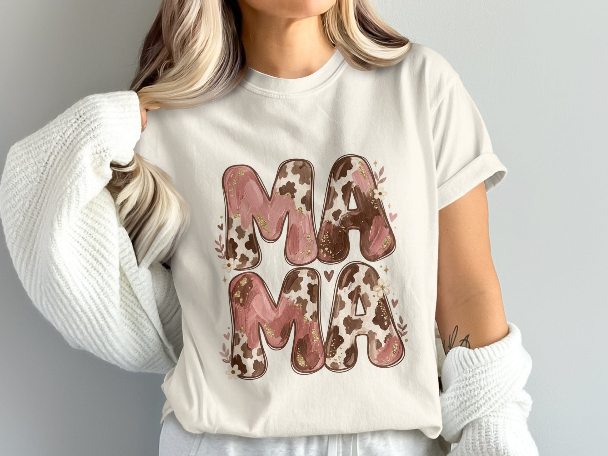 White t-shirt with "MAMA" in pink and brown marbled letters with gold glitter.