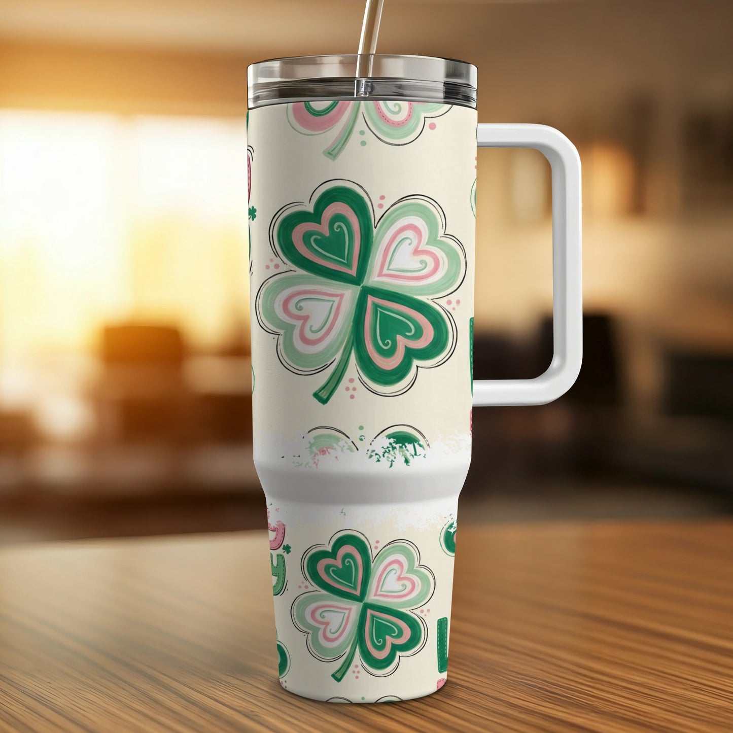Green and pink clover patterned tumbler with handle.