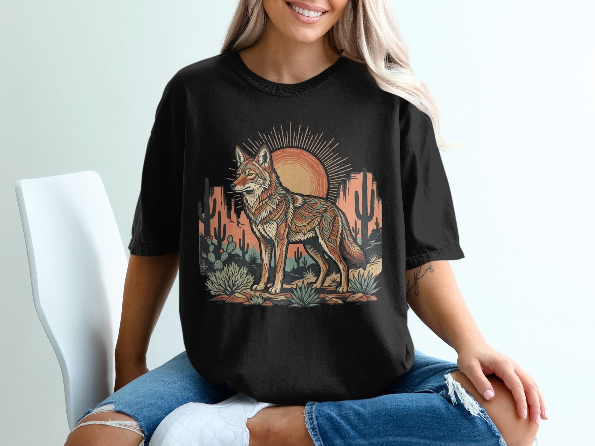 T-shirt graphic featuring a desert scene with a stylized coyote and sun.