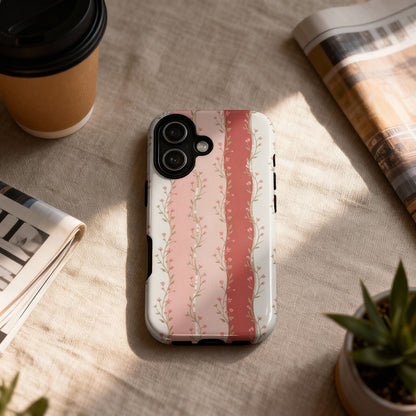Phone case with pink floral stripes on a textured surface next to a coffee cup.