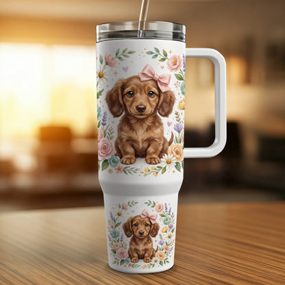 Dachshund puppy with pink bow on a white tumbler with floral accents.