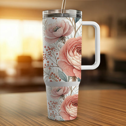 Floral tumbler with pink roses and berries on a wooden surface.
