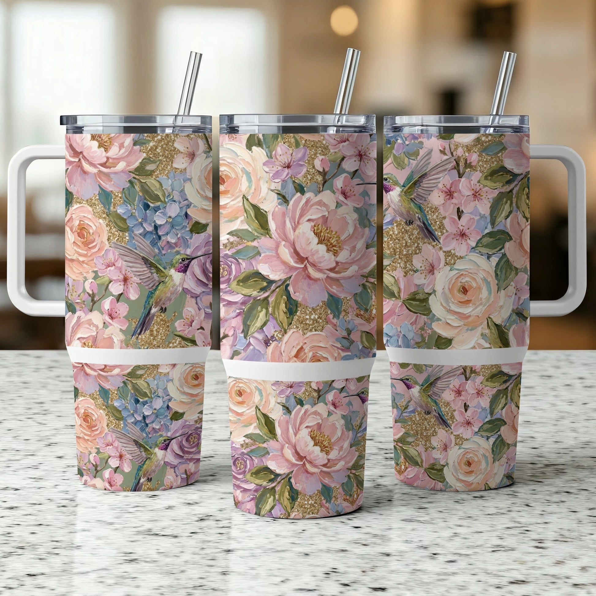 Three tumblers with hummingbird and floral patterns, and handles.