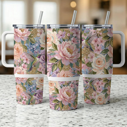 Three tumblers with hummingbird and floral patterns, and handles.