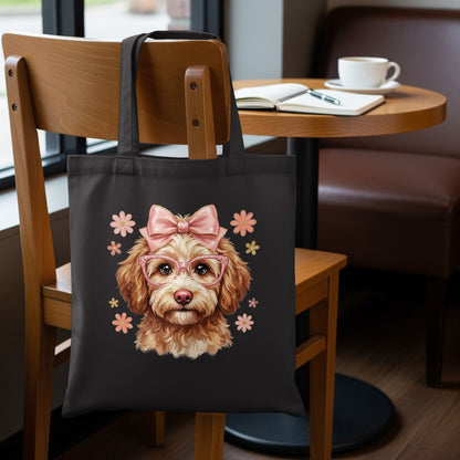 Black tote bag with a doodle dog wearing pink glasses and a bow.
