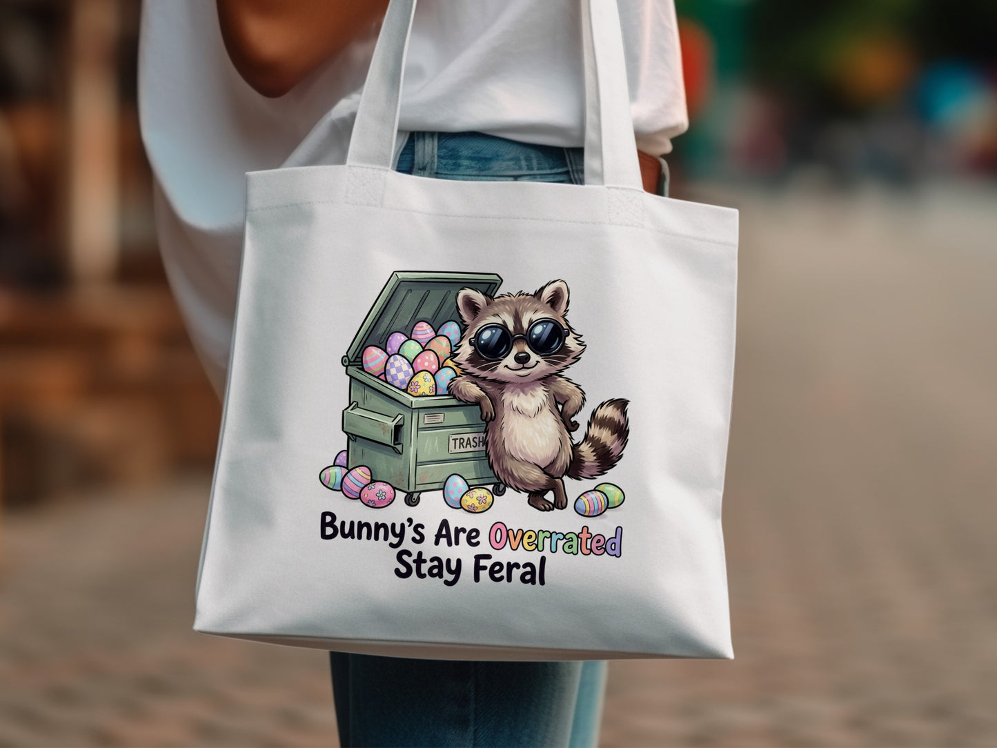 Raccoon in sunglasses sitting on trash can with Easter eggs, text "Bunny's Are Overrated Stay Feral".