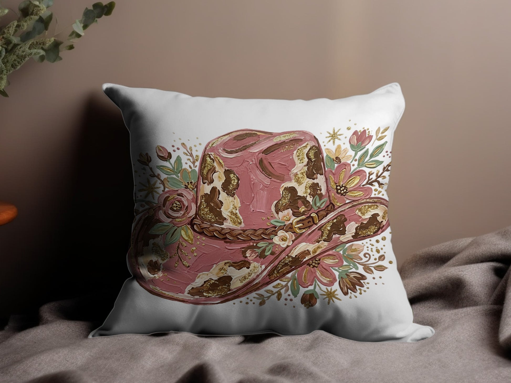 Pink and gold floral cowboy hat illustration on decorative throw pillow.
