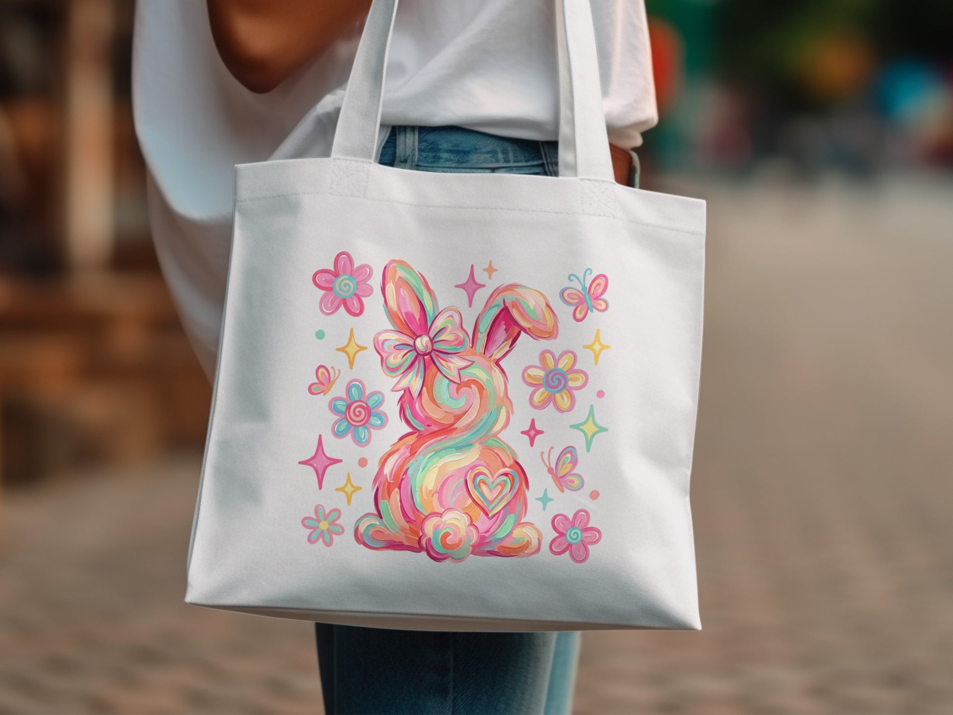 White tote bag with a colorful rainbow bunny and flowers.
