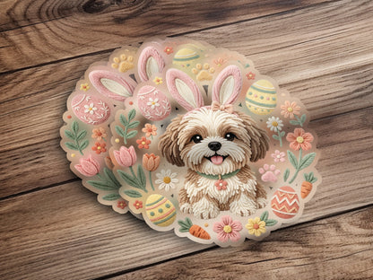 Shih Tzu dog wearing bunny ears surrounded by Easter eggs, flowers, and carrots.