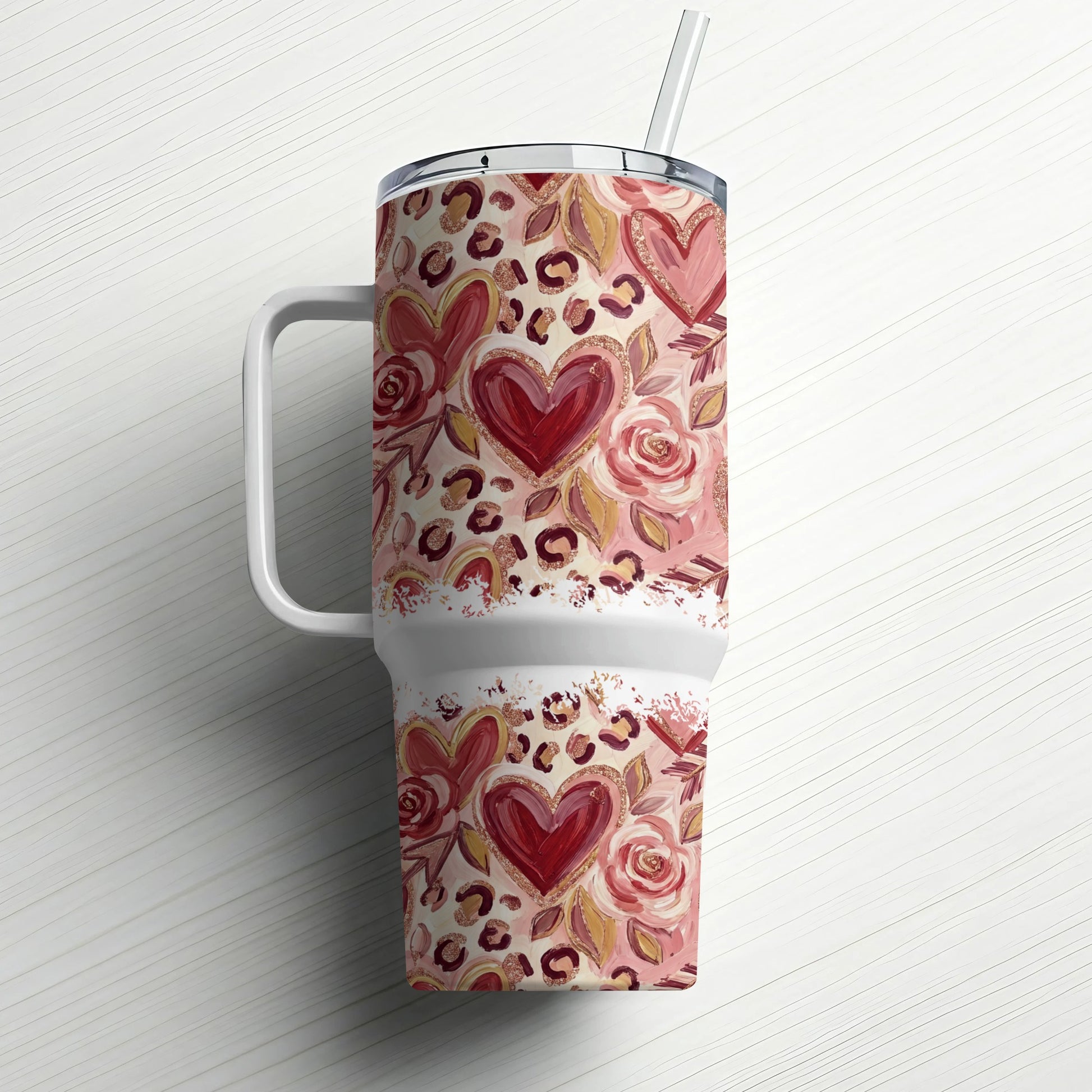 Travel tumbler with leopard print, hearts, and roses pattern, and a straw.
