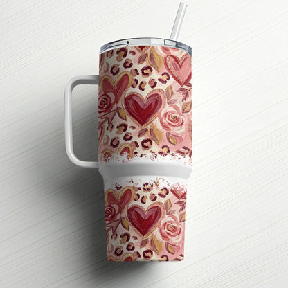 Travel tumbler with leopard print, hearts, and roses pattern, and a straw.